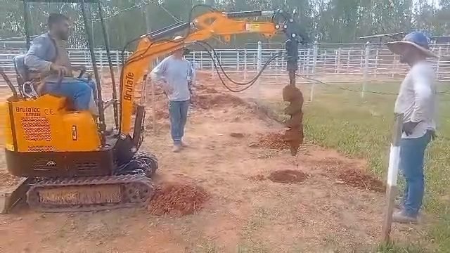 Perfuratriz abrindo furo no solo com a mini escavadeira